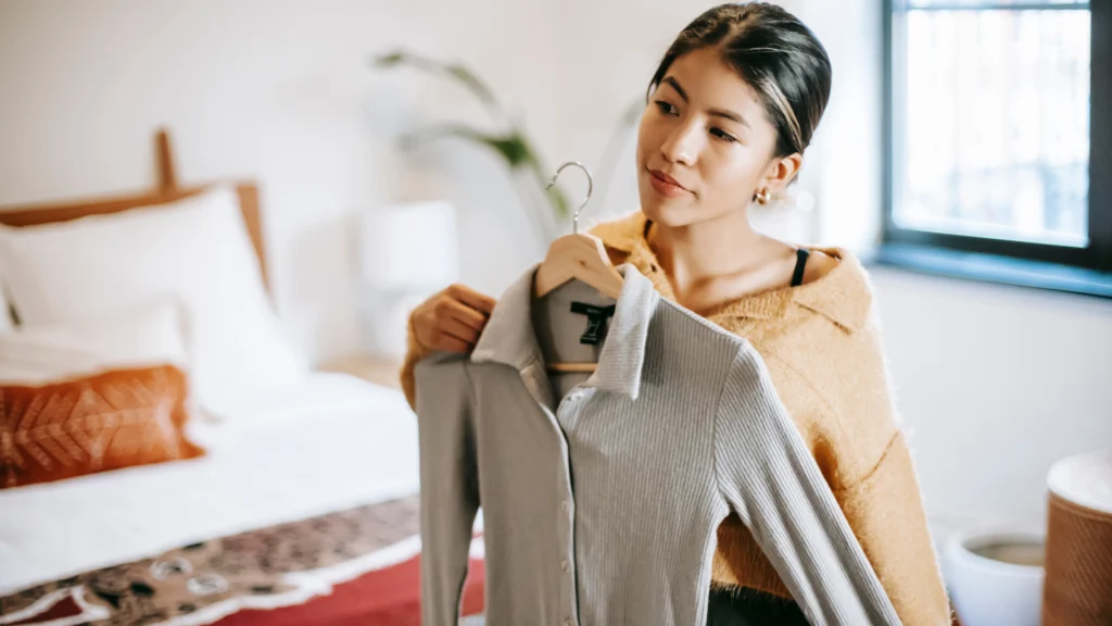 Women holding a shirt up in front of mirror